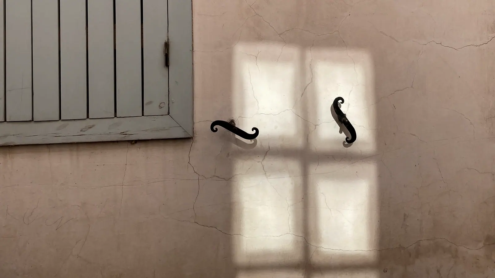 Window shadow falling across a pale interior wall