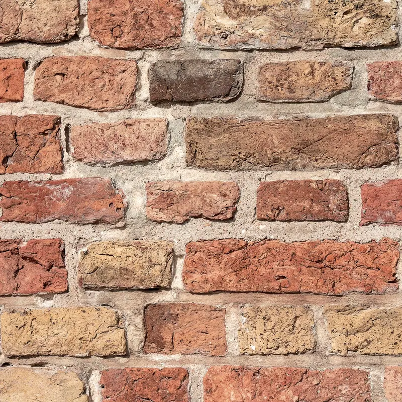 Coursed red laterite blockwork in raking light