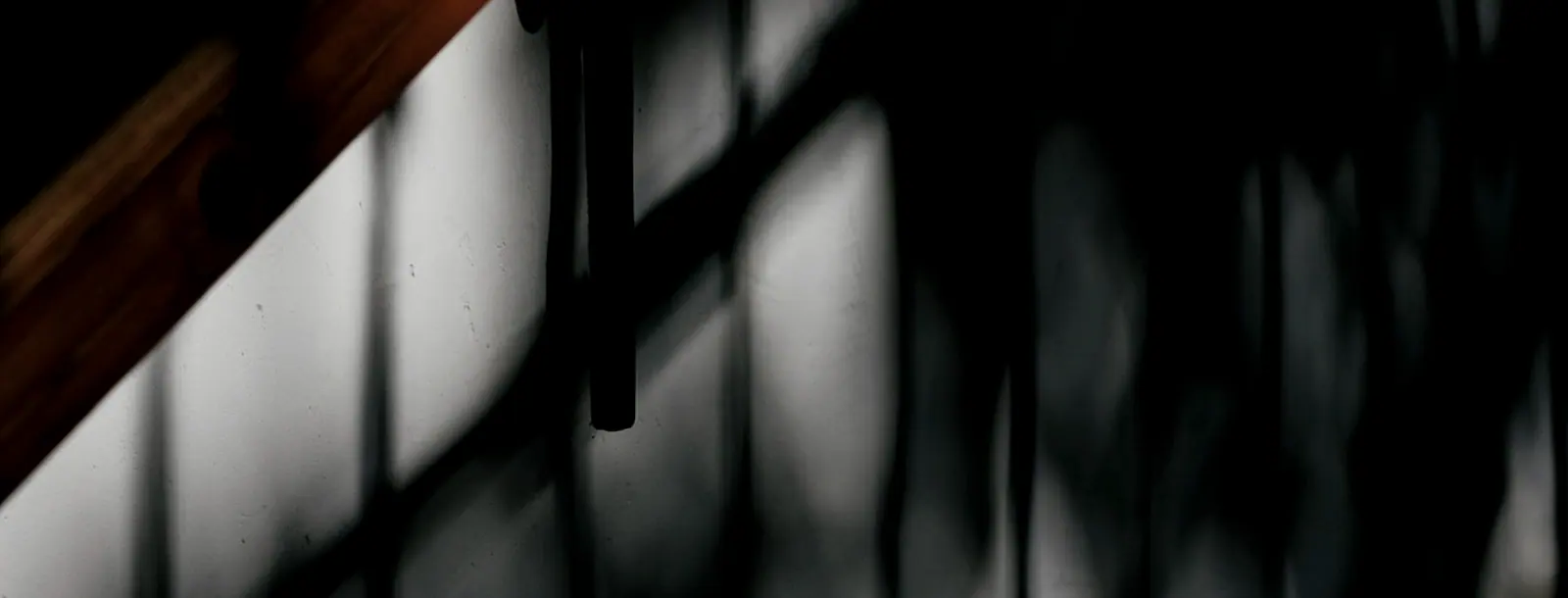 Rain-dark wall with a shaft of window light