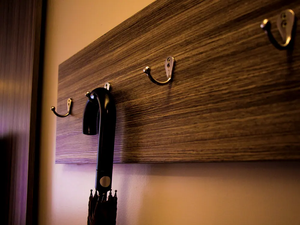 Brass hooks set into a fumed teak wall panel