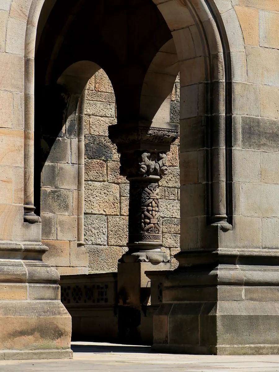 Stone arcade in deep shadow with a single lit opening beyond