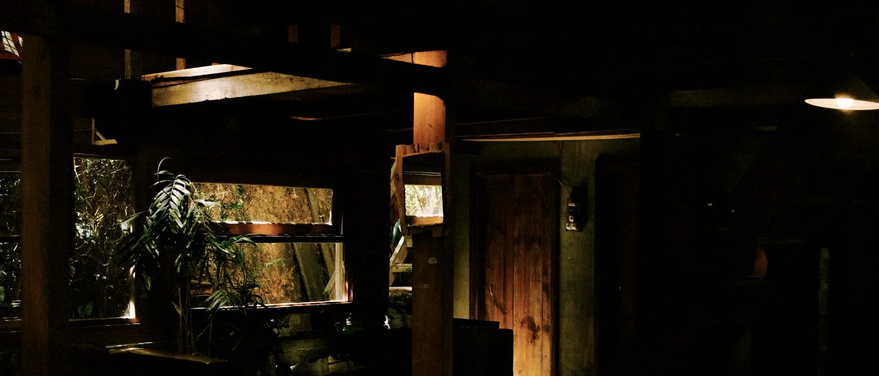 Warm interior seen from the dark verandah at dusk
