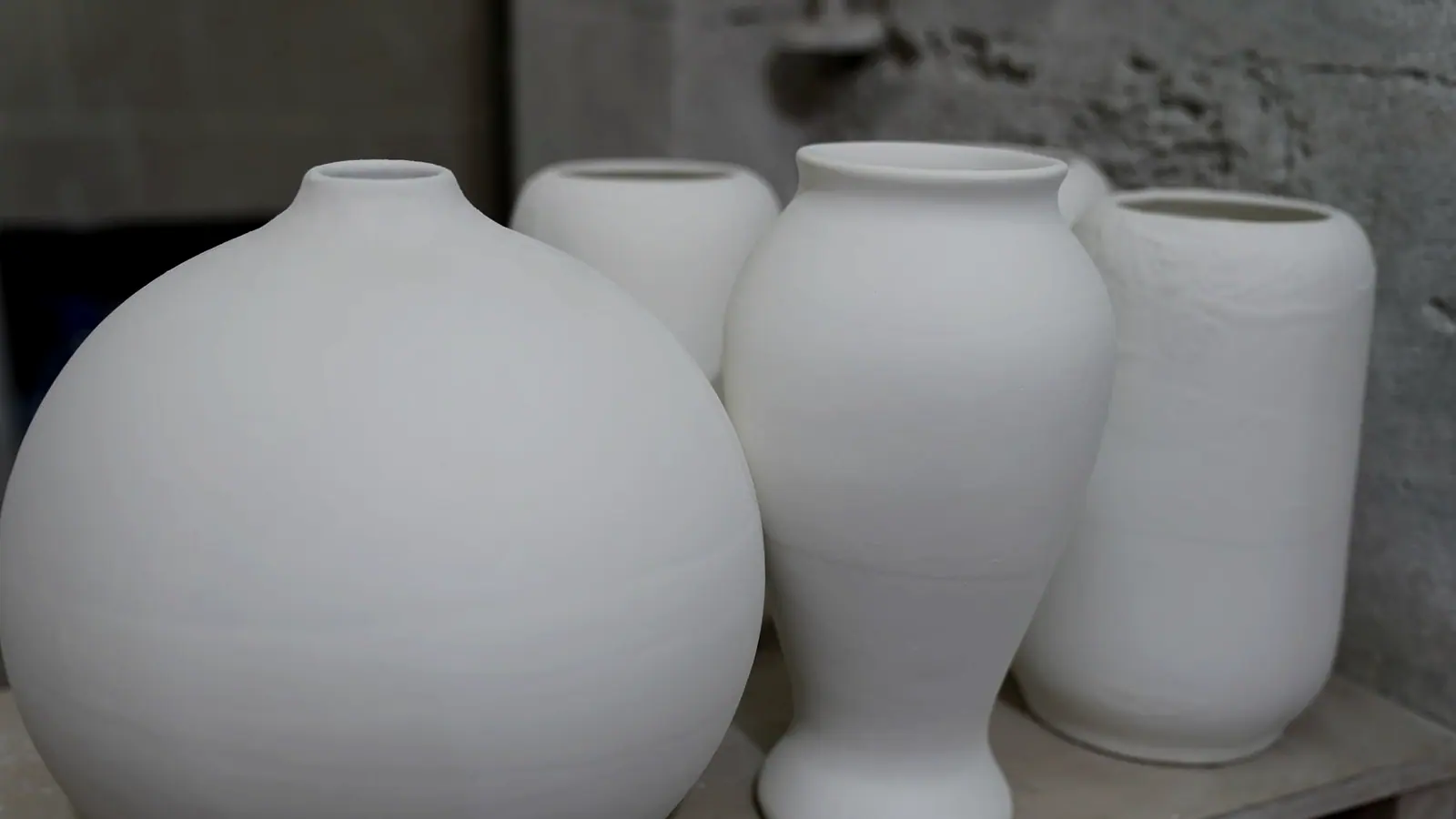 A row of finished vessels lined up against a white wall
